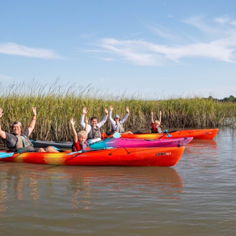 a group of people in a small boat in a body of water