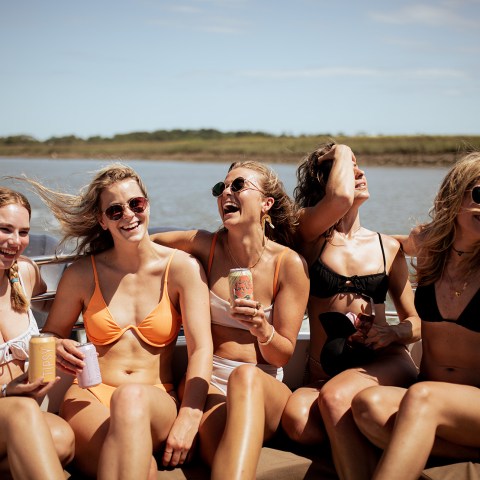 a group of people sitting on a bench next to a body of water