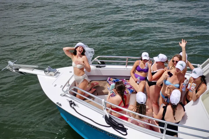 a bachelorette glowing as she experiences being the center of attention on a boat