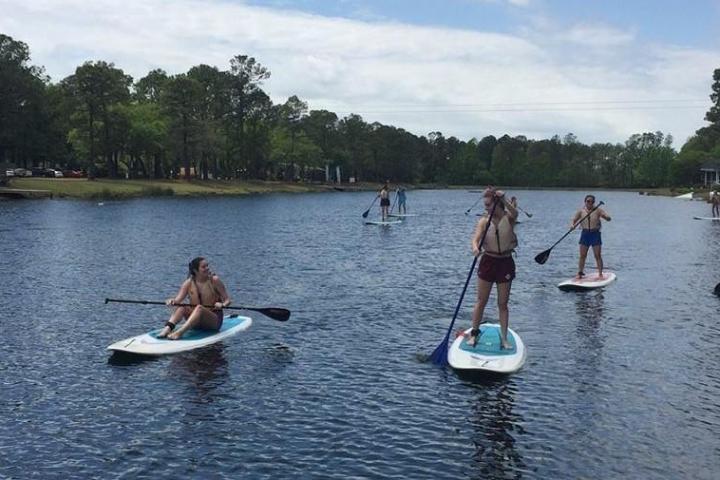 a group of people riding on the back of a boat in the water