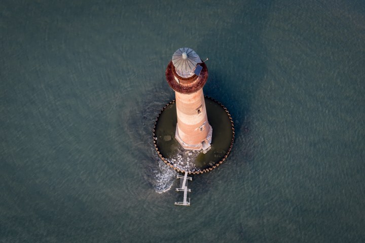Aerial view of a lighthouse surrounded by water.